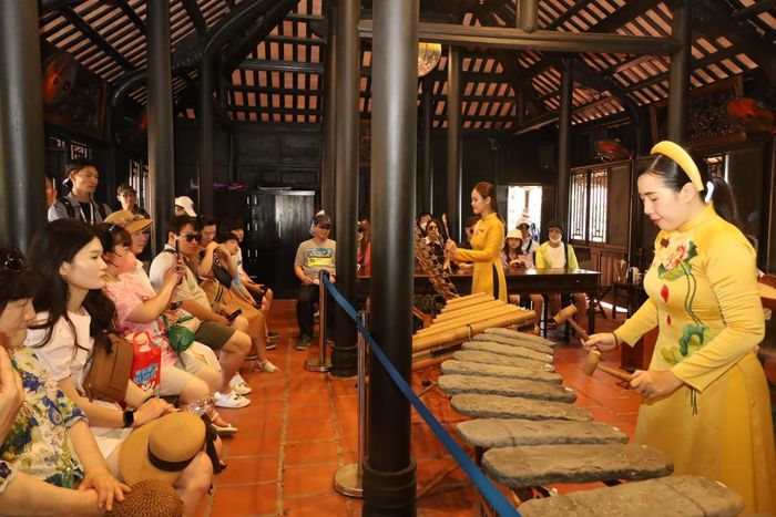 Biểu diễn nhạc cụ đàn đá phục vụ du khách ở danh thắng Hòn Chồng.