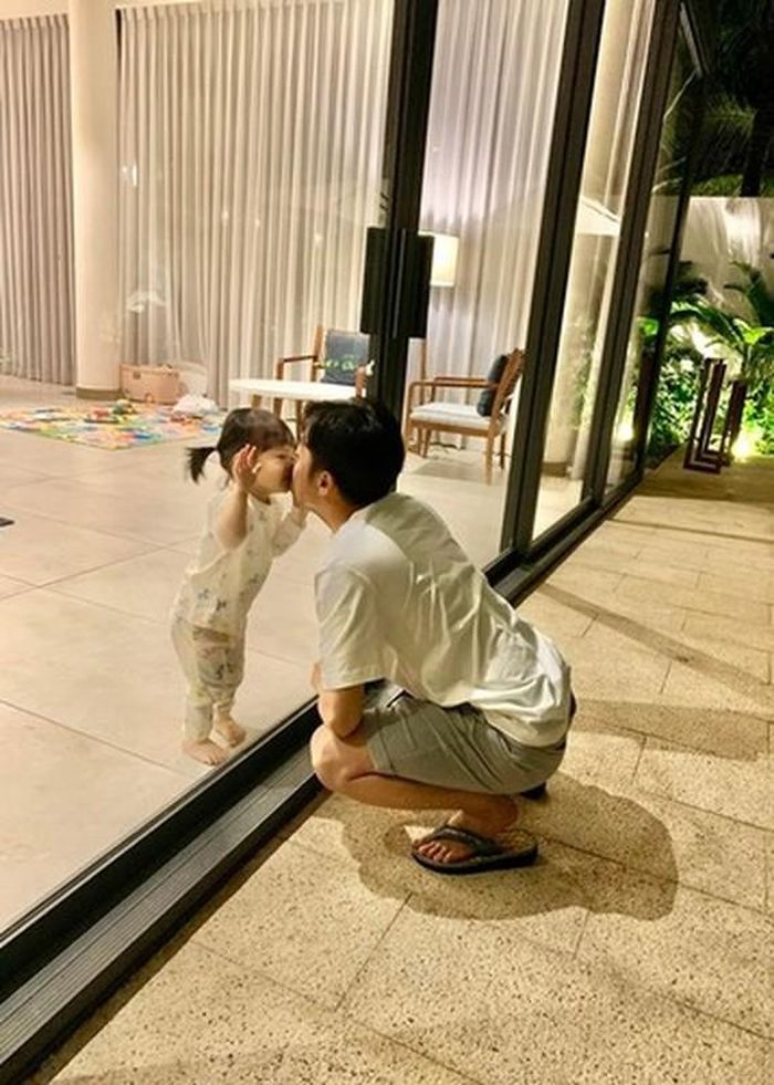 "Đã yêu rồi thì.. bất chấp luôn", Cường Đô la chú thích cho khoảnh khắc hôn con gái qua kính.