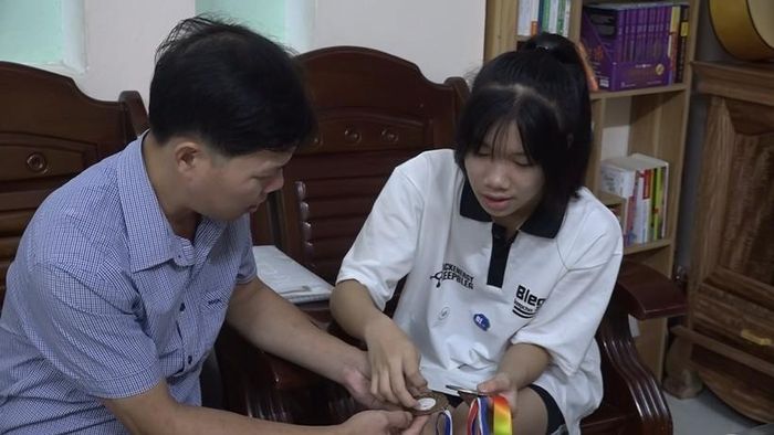 Minh Thanh cùng bố ôn lại thành tích thể thao em đạt được.