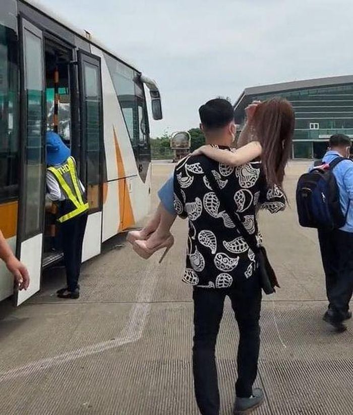  Hành động bế vợ lên máy bay của chàng trai gây tranh cãi. Ảnh: Dung Chính