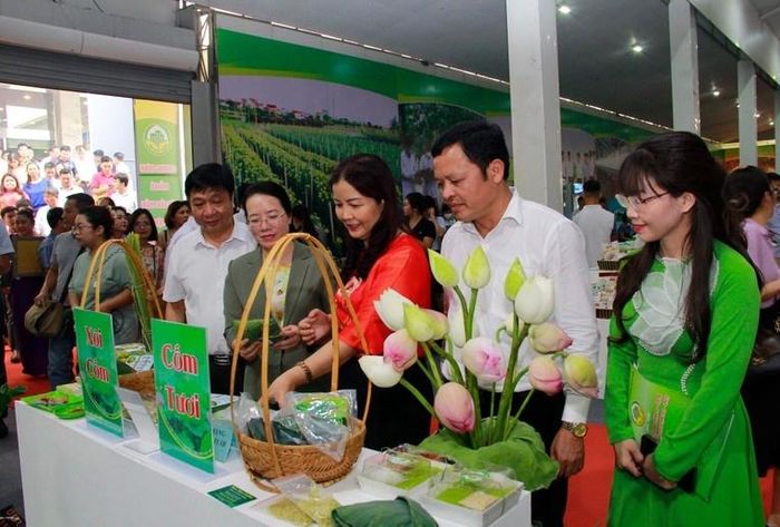 Bà Trần Thị Phương Lan (áo đỏ) – Quyền Giám đốc Sở Công thương Hà Nội cùng các quan khách tham quan gian hàng trưng bày tại buổi xúc tiến thương mại, giới thiệu sản phẩm hàng hóa OCOP ngày 16/6.