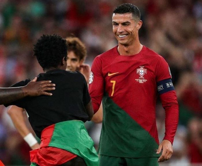  Trước tình cảm của người hâm mộ, CR7 cũng nở nụ cười tươi. Sau khi hoàn thành giấc mơ được gặp thần tượng, chàng trai này tiếp tục giương cao quốc kỳ Bồ Đào Nha rồi chạy dọc sân trước khi bị đội ngũ an ninh sân khống chế. 