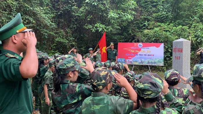 Các học sinh nghiêm trang trước cột mốc quốc giới.