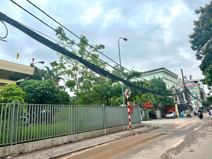 Búi dây điện buông thõng trước cửa Bệnh viện 19-8 số 9 Trần Bình, phường Mai Dịch (quận Cầu Giấy).