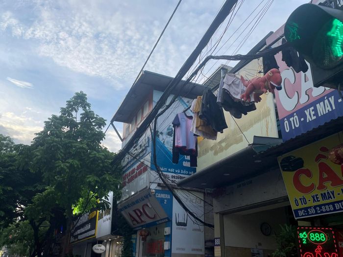 Người dân vô tư dùng búi dây điện, cáp trên cao làm dây phơi quần áo tại số 886- 888 đường Láng (quận Đống Đa).