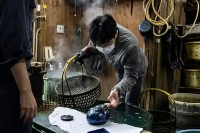 Những người thợ thủ công làm tối bề mặt của đồng bằng dung dịch lưu huỳnh. Ảnh: Thomas Nicolon
