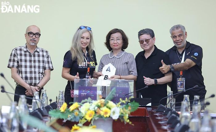 Phó Chủ tịch UBND thành phố Ngô Thị Kim Yến (giữa) đại diện Ban giám khảo bốc thăm thứ tự hai đội sẽ trình diễn tại đêm chung kết.