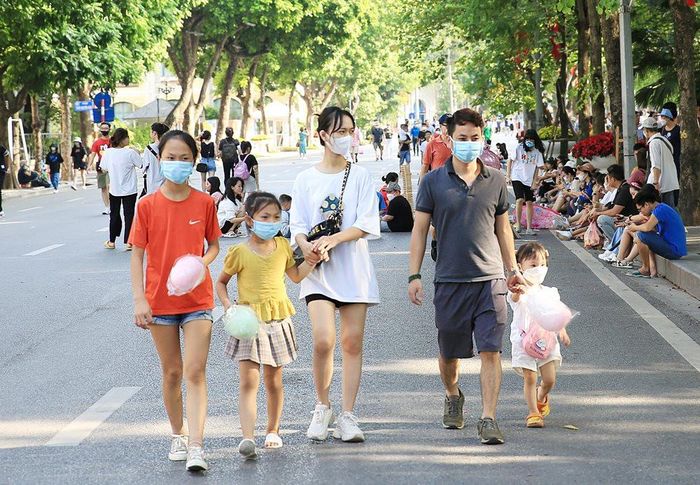 Một gia đình tay trong tay dạo chơi tại khu vực hồ Hoàn Kiếm (quận Hoàn Kiếm).
