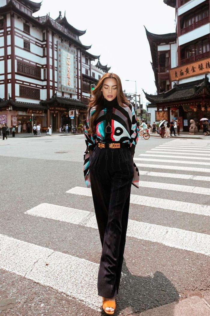 Hà Hồ dạo phố trong set đồ kín đáo mà hợp mốt với áo blouse cánh dơi nhiều màu và quần ống rộng tone-sur-tone. Nữ ca sĩ kết hợp cùng thắt lưng kim loại và sandal màu cam nổi bật.
