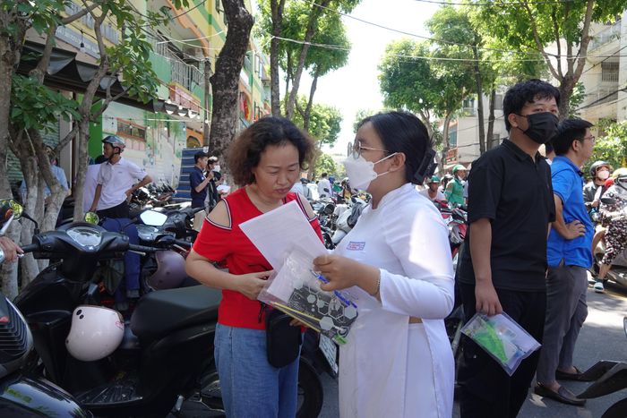  Một thí sinh vui vẻ đề cập đề thi năm nay với phụ huynh. Ảnh: XUÂN QUỲNH 