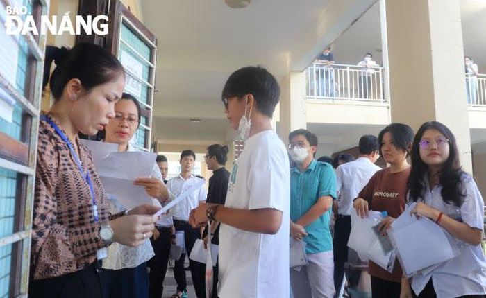 Cán bộ coi thi gọi thí sinh vào phòng thi. Ảnh chụp tại điểm thi Trường THPT Trần Phú.