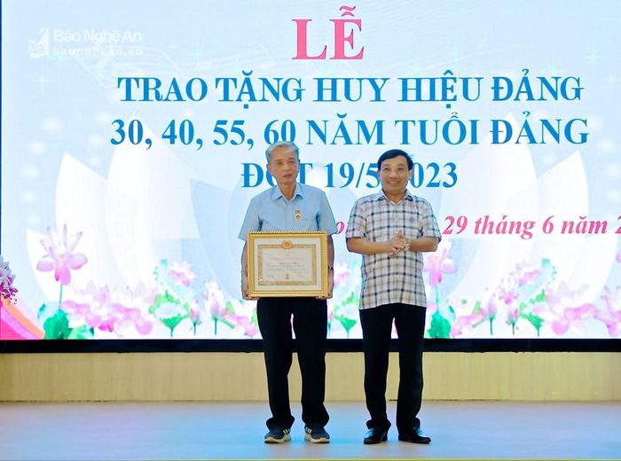  Phó Bí thư Thường trực Huyện ủy Nghi Lộc Nguyễn Thanh Hải trao tặng Huy hiệu 60 năm tuổi Đảng cho đảng viên Nguyễn Thanh Tiên. Ảnh: Mỹ Nga 
