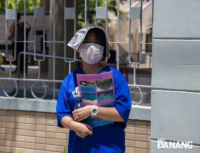 Một thí sinh chờ bố mẹ đến đón sau khi hoàn thành bài thi các môn tổ hợp vào sáng 29-6.
