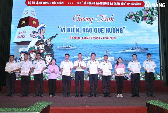Đại diện Bộ Tư lệnh Vùng 3 Hải quân (giữa) và CLB “Vì Hoàng Sa - Trường Sa thân yêu” thành phố Đà Nẵng (thứ 4, trái sang) trao tặng 10 suất học bổng cho con quân nhân Vùng 3 Hải quân. Ảnh: LÊ HÙNG