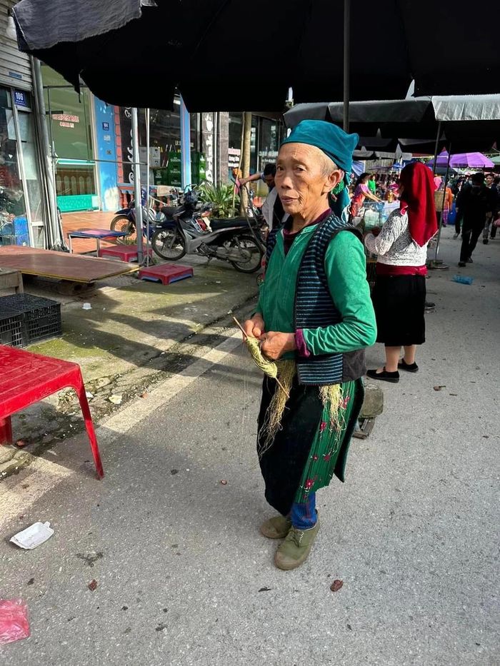 Người mẹ H'Mông vừa đi vừa thoăn thoắt đôi tay se lanh.