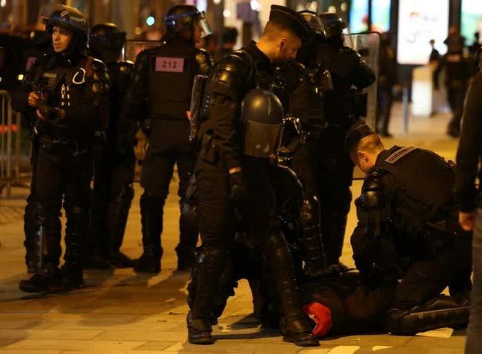 Cảnh sát Pháp bắt giữ người biểu tình bạo loạn tại Paris, tối 2/7/2023. Ảnh: AFP/TTXVN