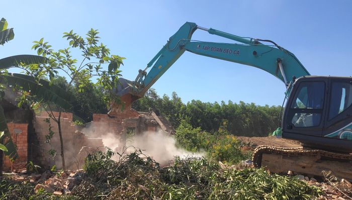 Dùng xe cơ giới tháo dỡ công trình kiến trúc để sớm có mặt bằng.