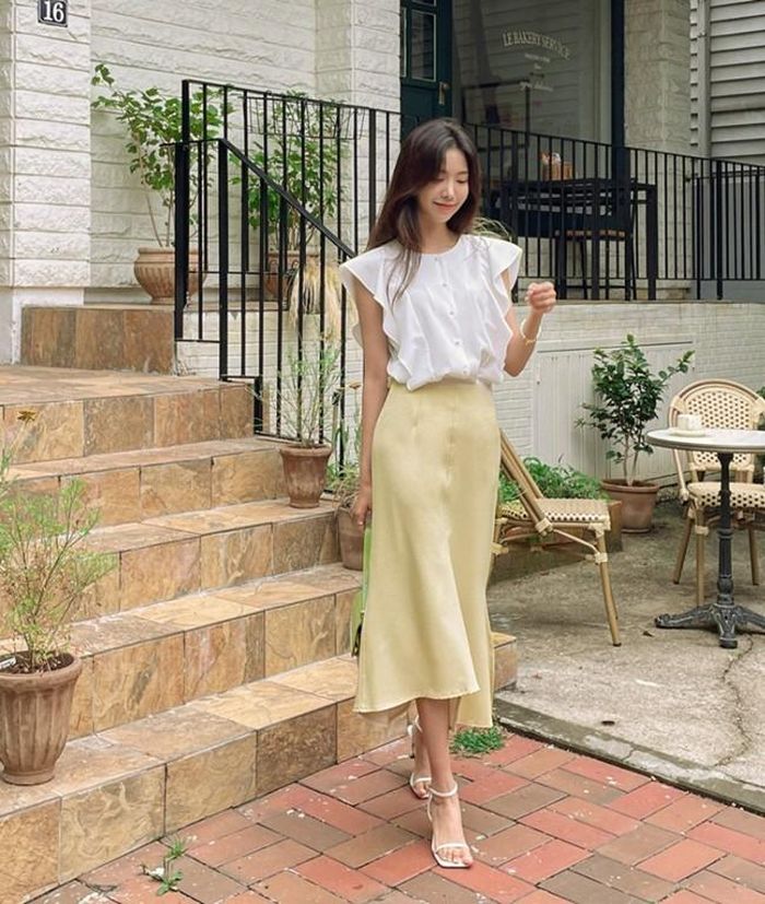 Áo không tay có chi tiết bèo nhún nhẹ nhàng kết hợp cùng chân váy midi màu sắc nền nã mang tới sự trẻ trung, ngọt ngào cho các quý cô công sở. Đôi sandal quai mảnh tiệp màu áo cũng là điểm cộng về sự tinh tế, thanh lịch.