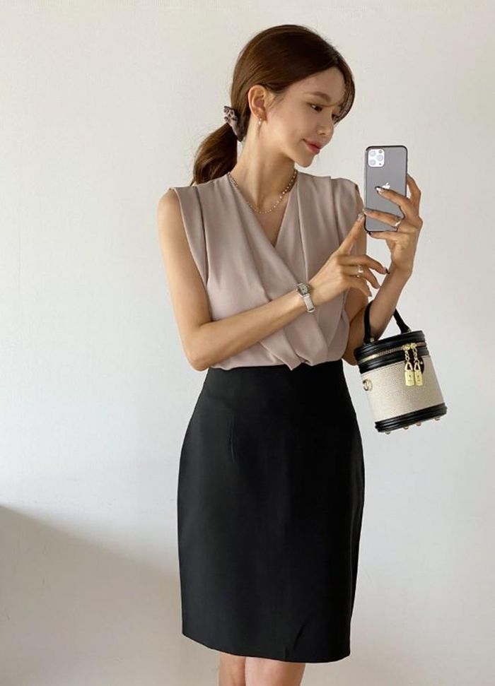 Thiết kế vạt đắp chéo tạo cảm giác dày dặn và thanh lịch hơn cho chiếc áo không tay màu nude. Mix với chân váy bút chì màu đen – item kinh điển của dân công sở, sẽ là gợi ý mặc đẹp cho bạn bất cứ ngày nào trong tuần.