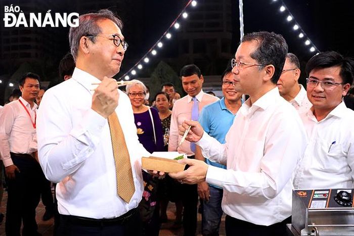 Bí thư Thành ủy Nguyễn Văn Quảng (bên phải) tham quan các gian hàng lễ hội cùng Đại sứ Nhật Bản tại Việt Nam Yamada Takio. Ảnh: X.D
