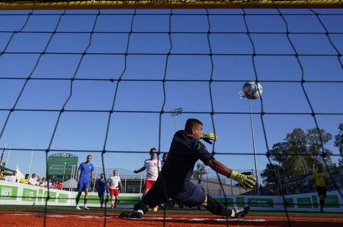 Cầu thủ đội tuyển Ba Lan đá thủng lưới đội tuyển Ukraine tại giải bóng đá World Cup vô gia cư. Ảnh: AP