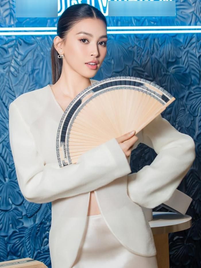 Người đẹp dùng quạt che phần ngực trước ống kính.
