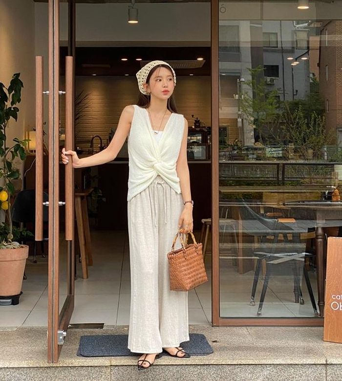 Áo không tay thiết kế xoắn vặn độc đáo khiến chiếc quần chun trông phong cách hơn hẳn. Set đồ ghi điểm bởi sự đồng điệu về màu sắc và những phụ kiện hợp với tinh thần mùa hè như túi cói, sandal mũi nhọn hợp trend.