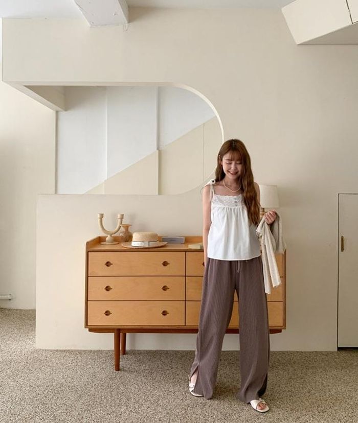 Áo dây dáng rộng điệu đà mix với quần chun màu đối lập giúp che giấu khuyết điểm vòng 2 khá hiệu quả. Chọn vòng cổ và sandal bệt cùng tông trắng như quý cô này để hoàn thiện set đồ đậm chất mùa hè.