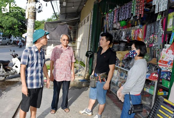  Ông Nguyễn Quốc Hội (thứ 2, trái sang) vận động các hộ kinh doanh hàng tạp hóa lắp đặt chuông báo cháy. Ảnh: Công Khang 