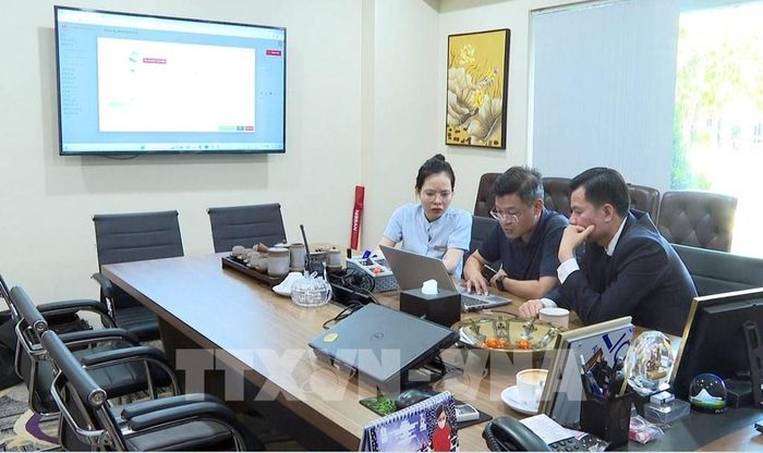 Cán bộ Trung tâm thông tin xúc tiến du lịch, Sở Du lịch tỉnh Ninh Bình (giữa) hướng dẫn Khách sạn Ninh Bình Legend cài đặt, đăng tải thông tin khách sạn lên các trang thông tin phục vụ du khách. Ảnh: Thùy Dung - TTXVN