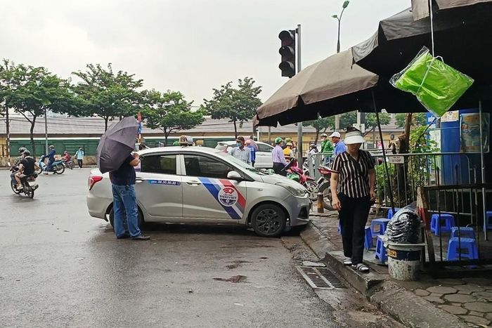 Ngay tại khu vực cổng vào dành cho xe buýt (đường Giải Phóng), một xe taxi ngang nhiên dừng, đỗ, đón khách dưới lòng đường.