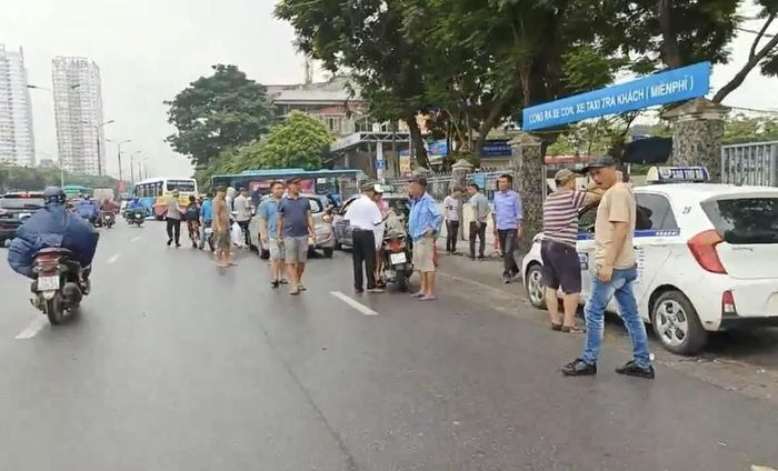 Xe taxi, xe hợp đồng, nhân viên các nhà xe... tràn ra khu vực cổng chính Bến xe Giáp Bát (đường Giải Phóng) chèo kéo khách.