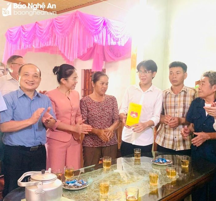 Đồng chí Võ Thị Minh Sinh trao quà của Hội đồng Dân tộc của Quốc hội cho em Cao Duy Thông. Ảnh: Đức Anh
