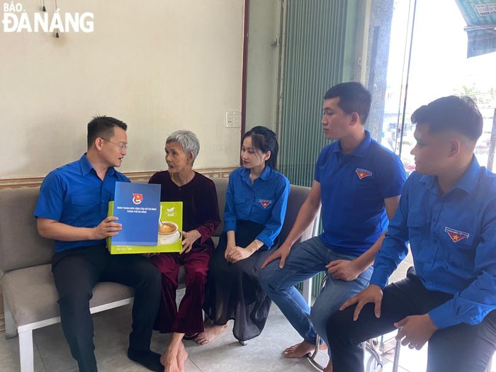 Bí thư Thành Đoàn Nguyễn Mạnh Dũng (bìa trái) đến thăm, tặng quà Bà mẹ Việt Nam anh hùng Phạm Thị Ta (trú phường Hòa Hiệp Nam, quận Liên Chiểu) sáng 22-7. Ảnh: THÀNH ĐOÀN