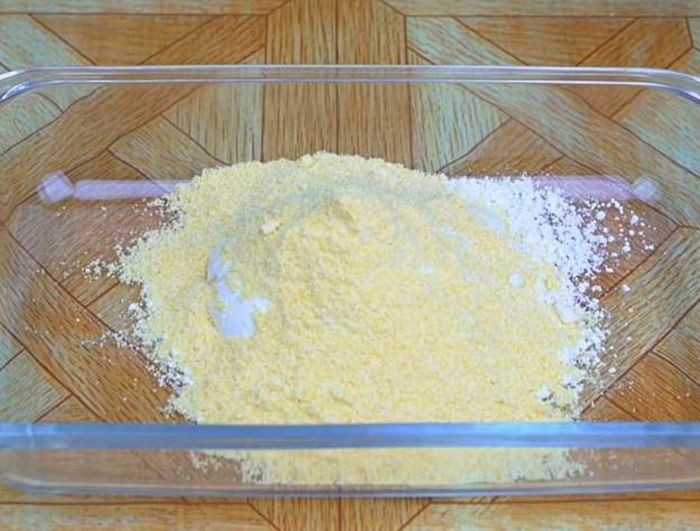 Trong lúc đó, các bạn lấy thố thủy tinh hoặc một chiếc bát tô to bất kỳ, cho vào đó 100 gram bột mì và 100 gram bột ngô...