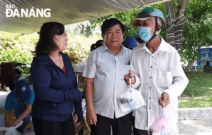 Ông Mốt (đầu tiên, từ phải qua) nhận những suất cơm về cho gia đình.