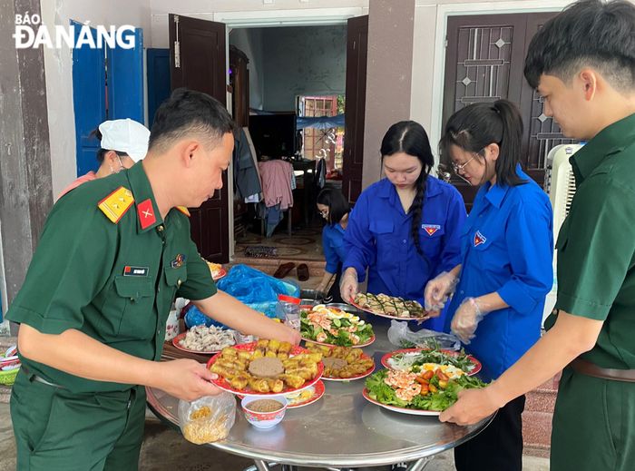 Các đoàn viên làm mâm cơm cúng giỗ các anh hùng liệt sĩ. Ảnh: T.PHƯƠNG