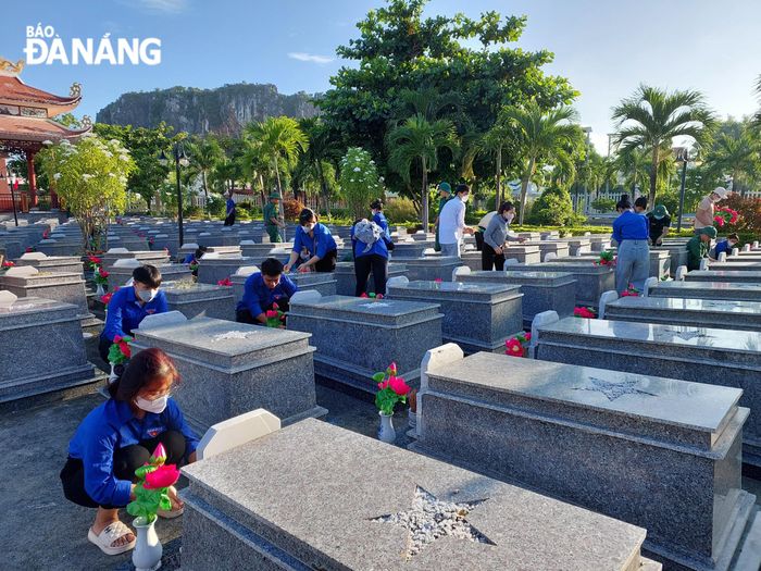 Các đoàn viên, thanh niên phường Hòa Hải (quận Ngũ Hành Sơn) trang trí các phần mộ liệt sĩ. Ảnh: X.HẬU