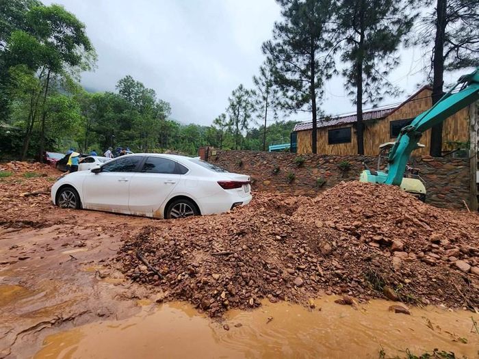 Đất bị nước lũ cuốn xuống đường chất thành từng đống. 