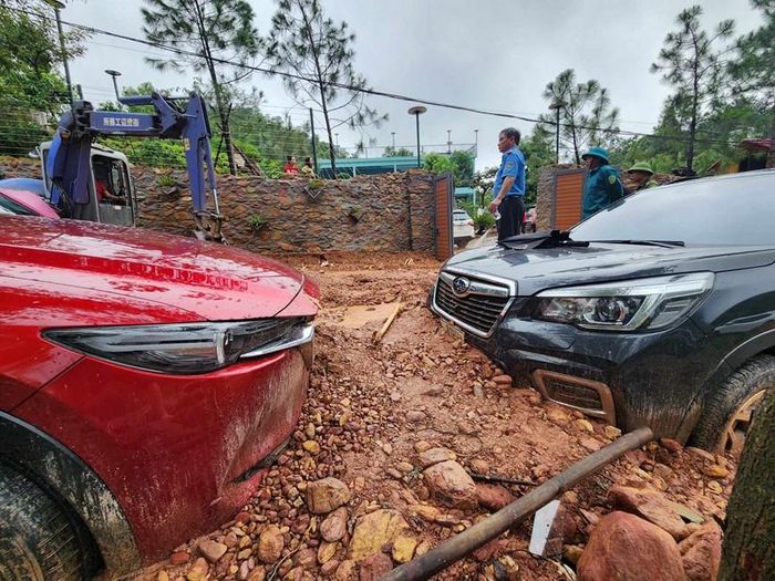 Đất đá tràn xuống đường ngập ngang bánh xe ô tô. 