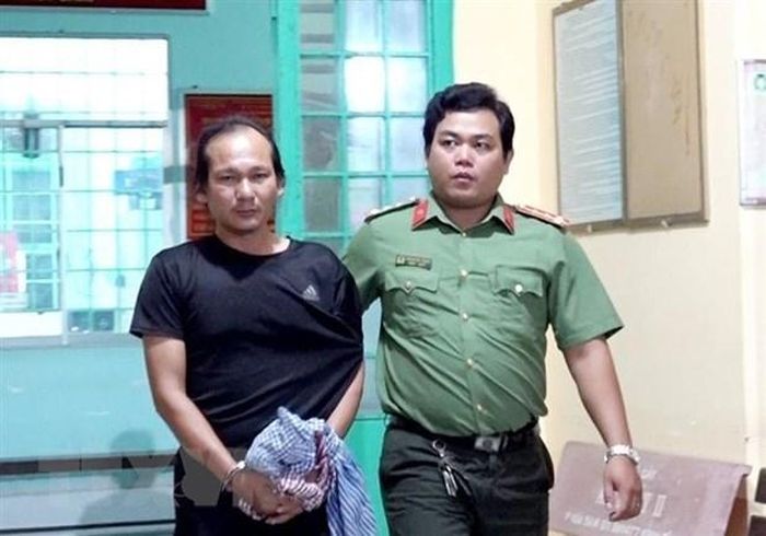 Lực lượng Công an bắt, áp giải Nguyễn Hoàng Nam về nơi giam giữ. (Ảnh: TTXVN)