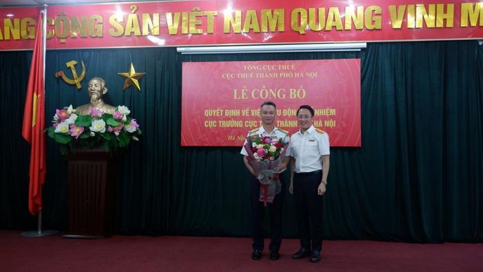 Ông Mai Sơn - tân Phó Tổng cục trưởng Tổng cục Thuế (Nguyên Cục trưởng Cục Thuế TP Hà Nội) tặng hoa chúc mừng tân Cục trưởng Cục Thuế TP Hà Nội Vũ Mạnh Cường