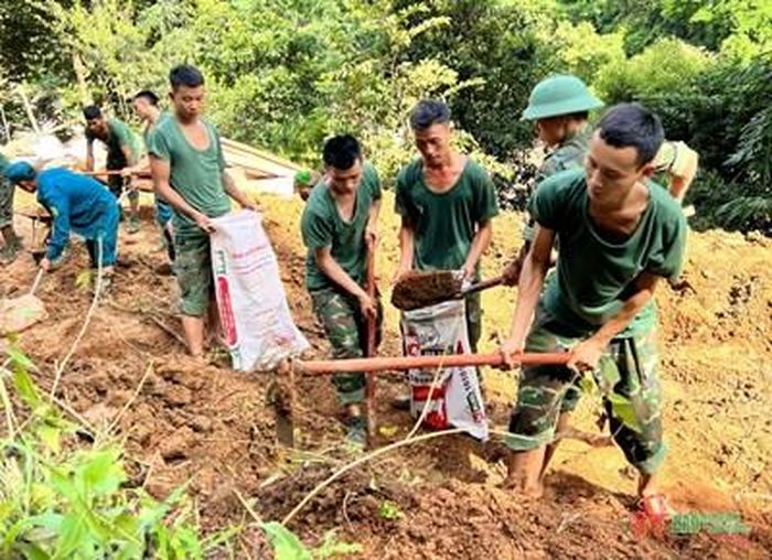  Cán bộ, chiến sĩ Trung đoàn 174, Sư đoàn 316 hỗ trợ người dân bản Trống Là, xã Hồ Bốn (Mù Cang Chải, Yên Bái) san gạt nền nhà.