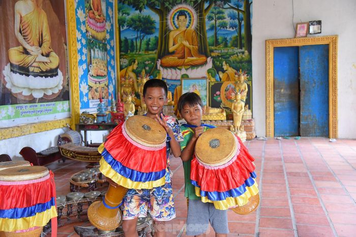  Trẻ em chơi nhạc cụ Rô băm của đồng bào Khmer. Ảnh: Hòa Hội. 
