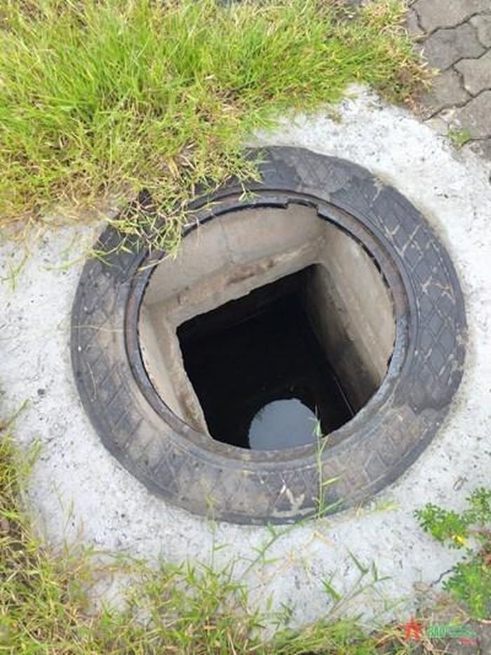 Nắp cống bị mất để lộ ra miệng cống sâu.