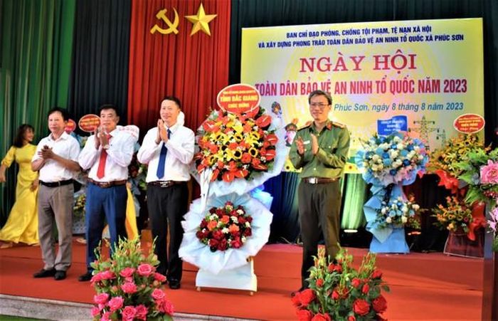 Đại tá Nguyễn Quốc Toản, Giám đốc Công an tỉnh tặng hoa chúc mừng Đảng bộ, chính quyền và nhân dân xã Phúc Sơn, huyện Tân Yên - Ảnh: VGP/Thiện Tâm
