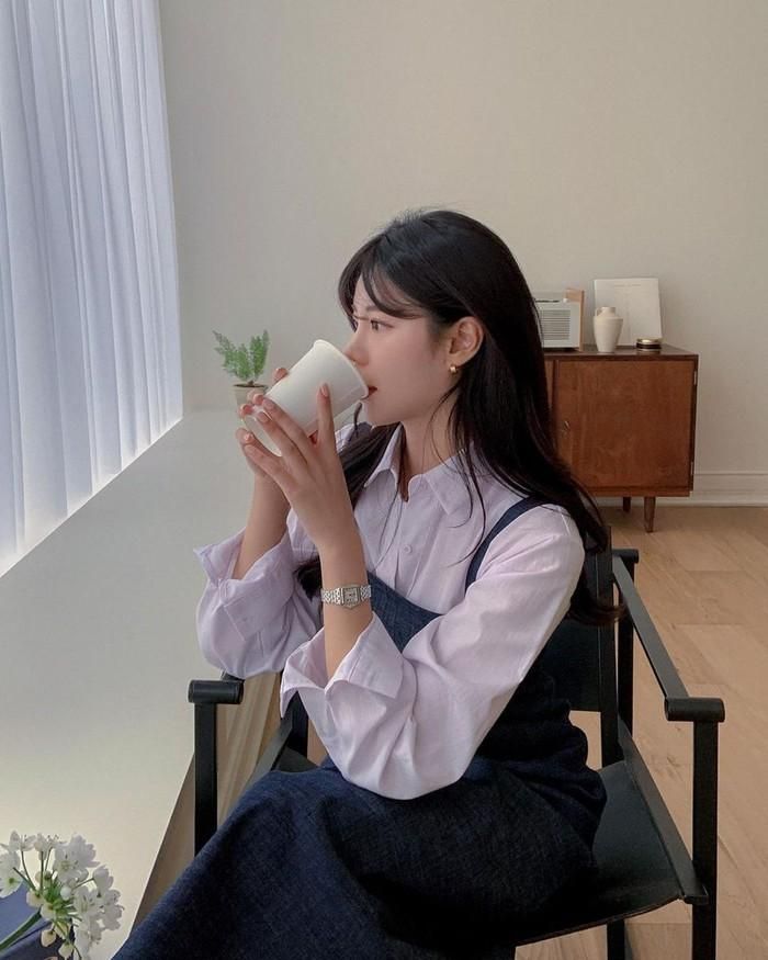 Ngoài mix với quần hay chân váy, áo sơ mi còn có thể kết thân với những chiếc váy liền 2 dây. Cách phối đồ này sẽ tạo cho chị em cảm giác ấm áp hơn vào những ngày trời lạnh.