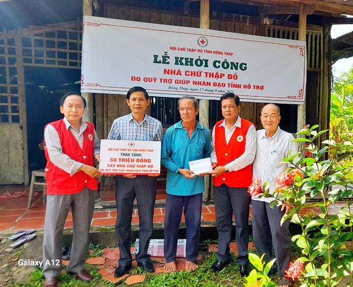 Đại diện lãnh đạo Hội Chữ thập đỏ huyện Lai Vung trao bảng tượng trưng hỗ trợ xây nhà cho hộ ông Phạm Văn Hiện (ấp Thới Hòa, xã Vĩnh Thới)