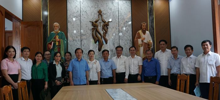 Đoàn công tác chụp hình lưu niệm tại Nhà thờ Giáo xứ Thành Đức trong khu tái định cư. Ảnh: Mạnh Thìn.