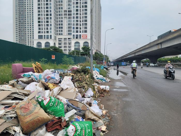 Rác thải, phế liệu xây dựng tràn từ vỉa hè xuống lòng đường.